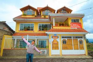 a man standing in front of a yellow house at Casa de Luis in Otavalo