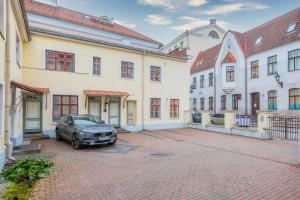 een auto geparkeerd op een parkeerplaats naast de gebouwen bij Gildi Apartment in Tartu