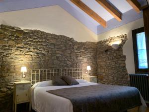 a bedroom with a large bed in a stone wall at Caserío de Fatás in Navasa
