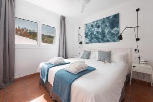 a white bedroom with two towels on a bed at Superior H - AD Alberto Dorner in Icod de los Vinos
