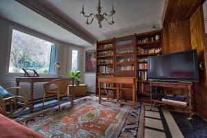 a living room with a flat screen tv and a piano at La casona de Mimi in Cercedilla