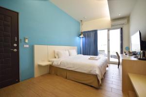 a bedroom with a bed with a blue wall at Taitung Venice B&B in Taitung City