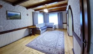 een woonkamer met een bank en een tapijt bij Котедж "Хата край села" in Tatariv