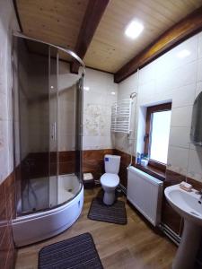 y baño con bañera, aseo y lavamanos. en Котедж "Хата край села" en Tatariv