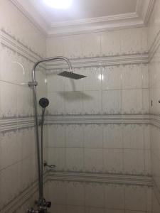 a shower in a bathroom with white tile at Elstine’s in Lagos