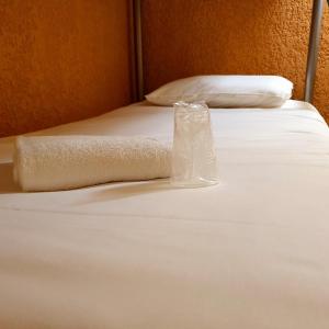 - un lit blanc avec un oreiller et une serviette dans l'établissement Libre Hôtel, à La Vespière