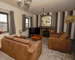 sala de estar con 2 sofás y chimenea en Conwy Valley Hotel Cottages, en Conwy