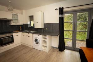 a kitchen with a washing machine and a window at Spring & Haven in Conwy