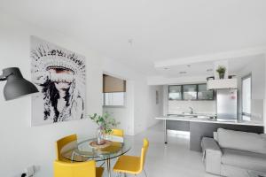 a living room with a glass table and yellow chairs at Glabur Stays - The Fabulous 2 BDR - Nicosia City, Free Parking & Wifi, Welcomes You!!! in Nicosia