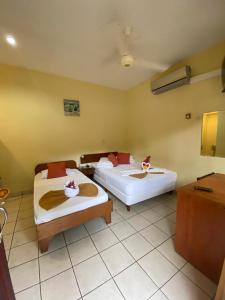 two beds in a hotel room with two bedsvisor at Hotel Nany in Brasilito
