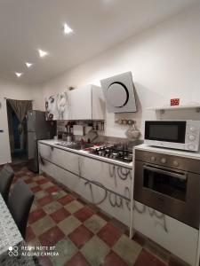 a kitchen with a stove and a microwave at Appartamento Via Filippini in Reggio di Calabria