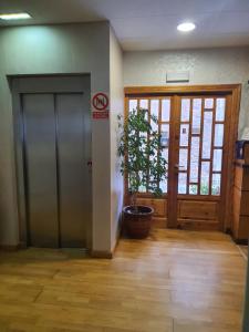 a hallway with a door and a potted plant at Hotel Gomar in San Martín de Moncayo
