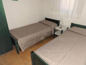 Pokój z dwoma łóżkami i lampką na stole w obiekcie Villa Agavi 3 w Bibione
