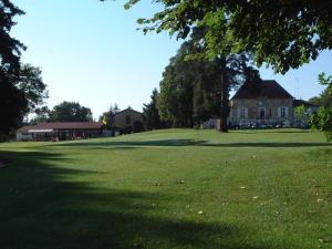 a large grass field with a house in the background at Gite - COTE GREEN in Combles-en-Barrois