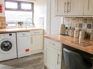 a kitchen with a washing machine and a sink at Little Barn in Keighley