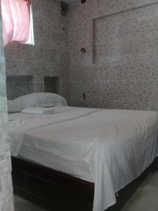 una camera da letto con un grande letto bianco e una finestra di Villa Julirous Rd spa and aparthotel camp for vacationers a Boca Chica