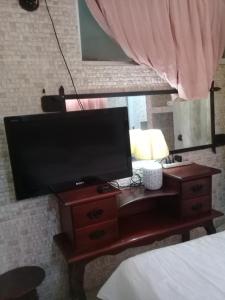 una televisione su un tavolo in una camera da letto di Villa Julirous Rd spa and aparthotel camp for vacationers a Boca Chica