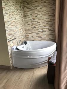 ein Bad mit einer weißen Badewanne in einem Zimmer in der Unterkunft Arenal Roca Suites in Fortuna