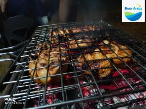 un montón de pollos cocinando en una parrilla en River Arena Holidays, en Vagamon