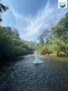 a person is splashing in the water in a river at River Arena Holidays in Vagamon