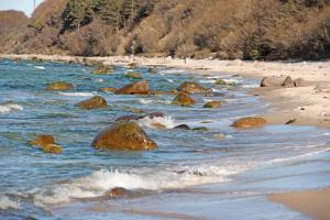 einen Strand mit Felsen im Wasser in der Unterkunft Ferienwohnung mit Balkon "Charming Holidays" in Binz