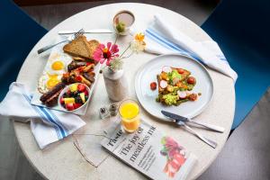 uma mesa com um prato de comida para o pequeno almoço e uma revista em Kimpton Schofield Hotel, an IHG Hotel em Cleveland