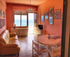 a living room with a table and a couch at Emozione Marina - appartamento fronte mare in Marcelli