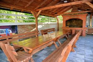 a group of wooden benches sitting in front of a fireplace at Drinsko jutro in Bijeljina