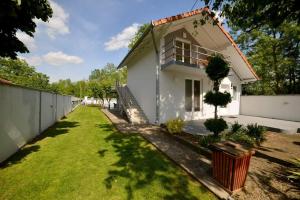 a white house with a fence and a grass yard at Drinsko jutro in Bijeljina