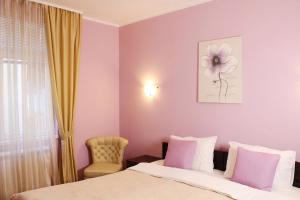 1 dormitorio con 1 cama y una flor en la pared en Apartments Paradisos, en Kragujevac 24 fotos más