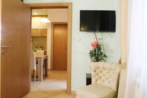 ein Wohnzimmer mit einem Stuhl und einem TV an der Wand in der Unterkunft Apartments Paradisos in Kragujevac
