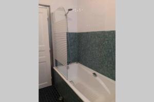 bagno con vasca e parete di piastrelle verdi di Gîte des Agapanthes a Lacroix-sur-Meuse Altre 16 foto