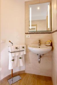 een badkamer met een wastafel, een spiegel en handdoeken bij Tre Raggi Apartment in Venetië