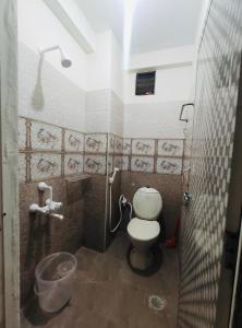 a small bathroom with a toilet and a shower at Little Island (Beach Cafe & Guest House) in Mahabalipuram
