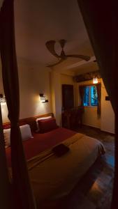 a bedroom with two beds and a ceiling fan at Little Island (Beach Cafe & Guest House) in Mahabalipuram