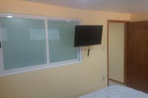 a bedroom with a window with a flat screen tv at San Marino in San Francisco Tlalnepantla