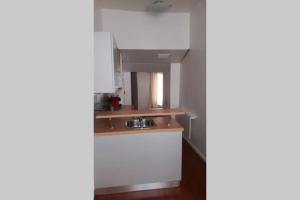 a kitchen with white cabinets and a sink at Appartement cosy dans le centre historique in Saint-Germain-en-Laye