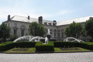 un grand bâtiment avec une fontaine devant lui dans l'établissement Appartement cosy dans le centre historique, à Saint-Germain-en-Laye