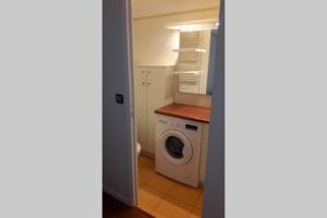 uma lavandaria com uma máquina de lavar roupa e uma máquina de lavar roupa em Appartement cosy dans le centre historique em Saint-Germain-en-Laye