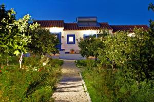 a white house with a pathway leading to a garden at Outeiro do Barro in Reguengos de Monsaraz