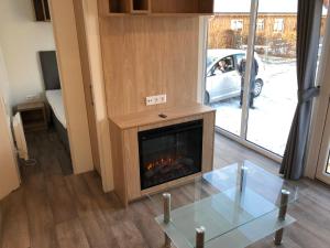 sala de estar con chimenea y mesa de cristal en Apartment im Herzen vom Unterallgäu, en Erkheim