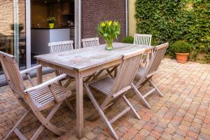 a wooden table with chairs and a vase of flowers at Menin Gate House in Ieper