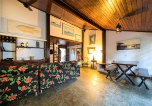 uma sala de estar com um sofá e uma mesa em Búzios Samba Suítes em Búzios