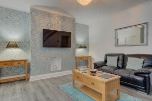 a living room with a couch and a tv at Sunderland Self-Catering 1 -Chester Cottage in Sunderland