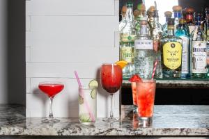 a group of four cocktails sitting on a bar at Kimpton Schofield Hotel, an IHG Hotel in Cleveland