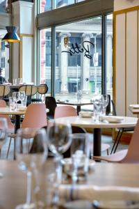 a restaurant with tables and chairs and windows at Kimpton Schofield Hotel, an IHG Hotel in Cleveland