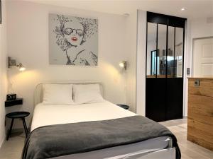 a bedroom with a bed and a painting on the wall at La Chantrerie in Cahors