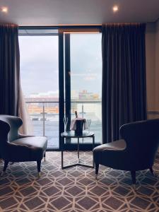 um quarto com duas cadeiras e uma grande janela em Seven Hotel em Southend-on-Sea