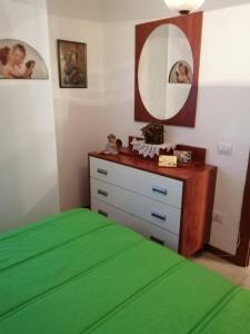 a bedroom with a bed and a dresser with a mirror at BEST HOUSE CAMPO DI GIOVE in Campo di Giove