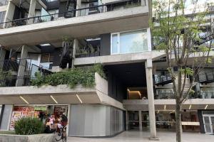 budynek z ludźmi siedzącymi na ławce przed nim w obiekcie Amazing apartment with amenities w BuenosAires